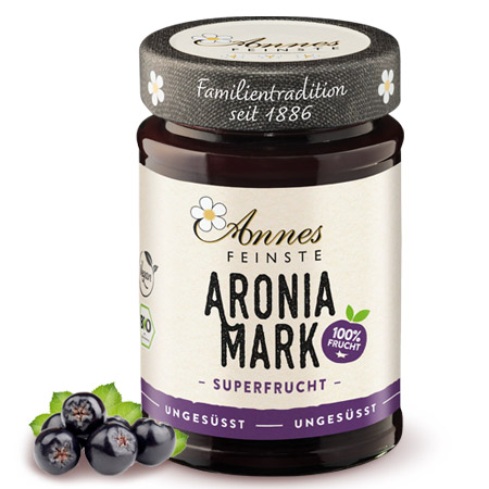 Annes Feinste Bio Aroniamark Glas Annes Feinste Bio Aroniamark, daneben Aroniabeeren.