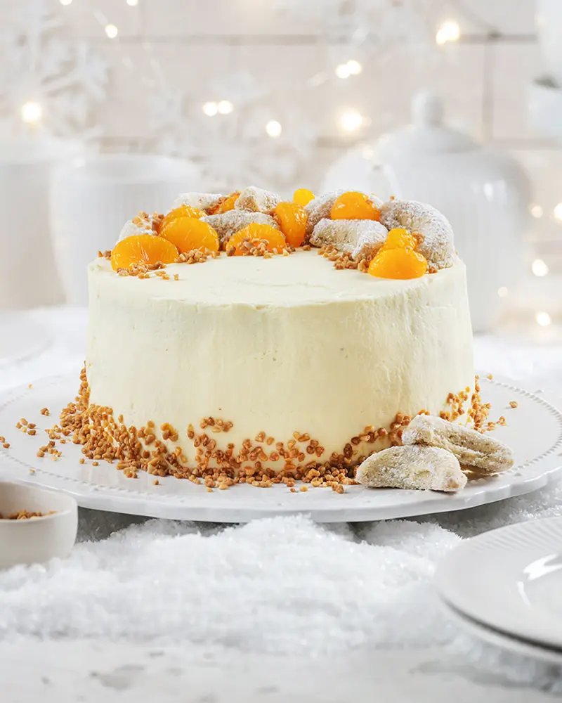 Vanillekipferltorte mit einer Mandarinen-Sahnecreme und Hagebutten-Konfitüre auf Tortenplatte.