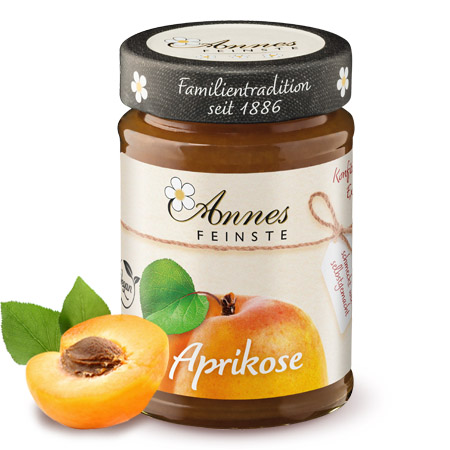 Annes Feinste Bio Aprikosen-Konfitüre extra Glas Annes Feinste Bio Aprikosen-Konfitüre extra, daneben halbe Aprikose.