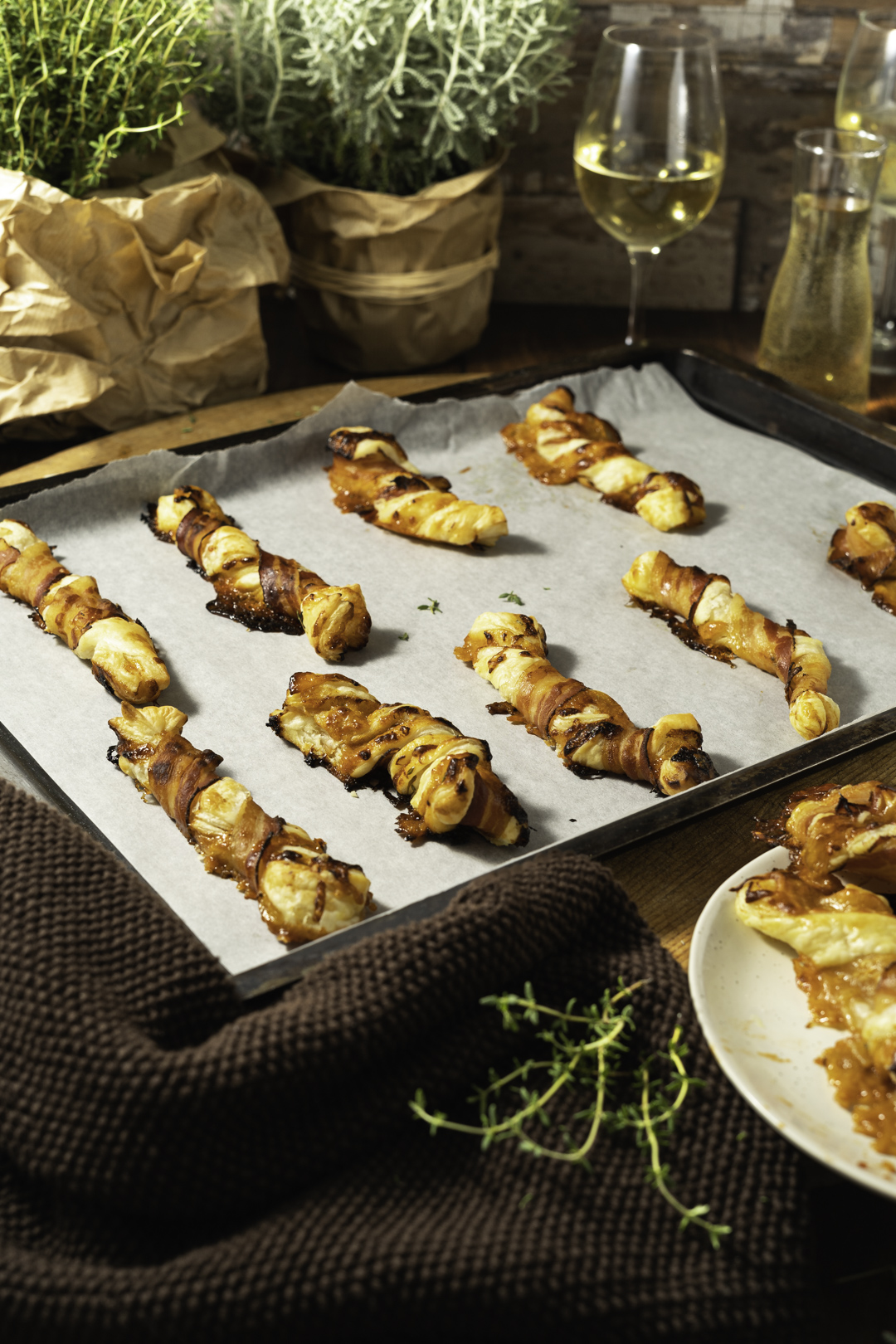 Gebackene Blätterteigstangen mit Bacon und Käse auf Backblech.