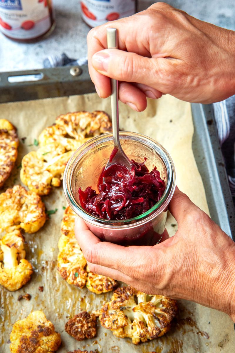 Blumenkohlsteak mit Hagebutten-Chutney Hagebutten-Chutney im Glas wir mit Löffel umgerührt.