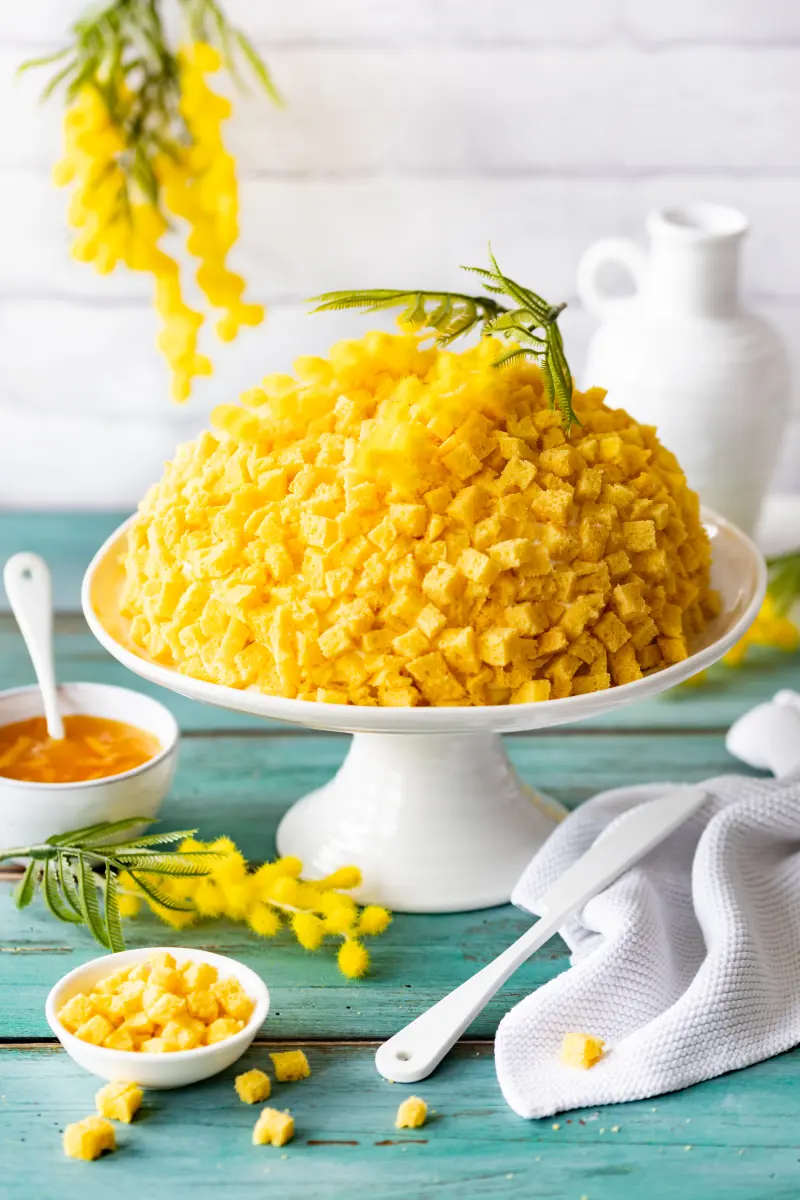Torta Mimosa mit Zitronencreme und Orangen-Marmelade Unangeschnittene Torta Mimosa auf einer Tortenplatte.