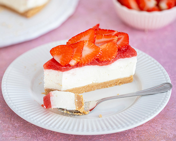 Stück von No Bake - Erdbeer-Mascarpone-Torte auf Teller mit Gabel.