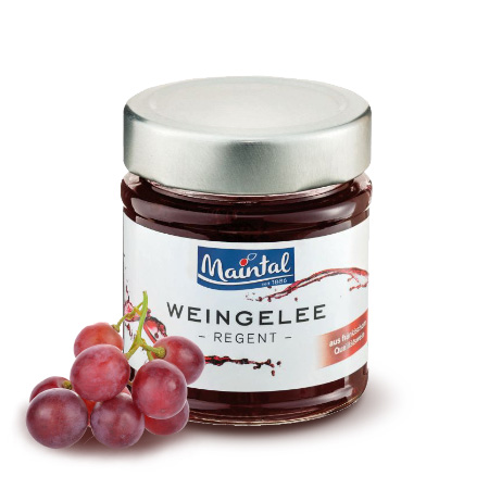 Rotwein Weingelee hergestellt aus fränkischem Regent Glas Weingelee Regent mit roten Trauben neben dem Glas, daneben rote Trauben.
