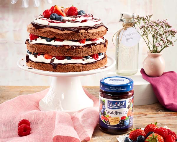 Mehrfrucht Fruchtaufstrich Waldfrucht, fein passiert Serviervorschlag Schwarzwälder Waldfruchttorte mit Fruchtaufstrich und Früchten auf Tortenplatte.