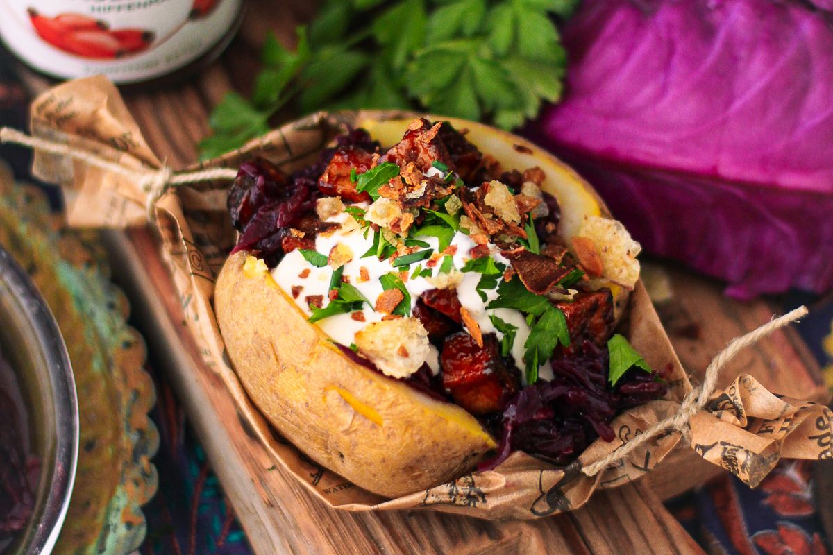 Ofenkartoffel mit Rotkohl und BBQ Tofu in Backpapierschiffchen. Serviervorschlag.