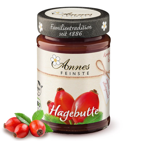 Annes Feinste Bio Hagebutten-Konfitüre extra Glas Annes Feinste Bio Hagebutten-Konfitüre extra, daneben Hagebutten.