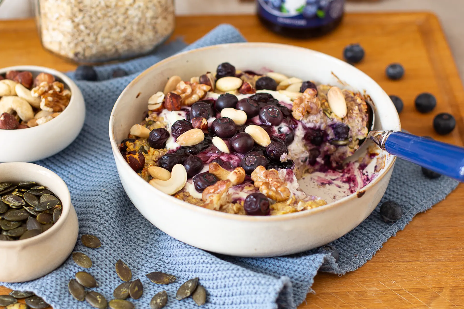 Proteinreicher Skyr-Auflauf mit Heidelbeeren, Nüssen & Haferflocken Skyr-Auflauf mit Heidelbeeren, Nüssen und Kürbiskernen, cremig gebacken und in einer Auflaufform serviert.