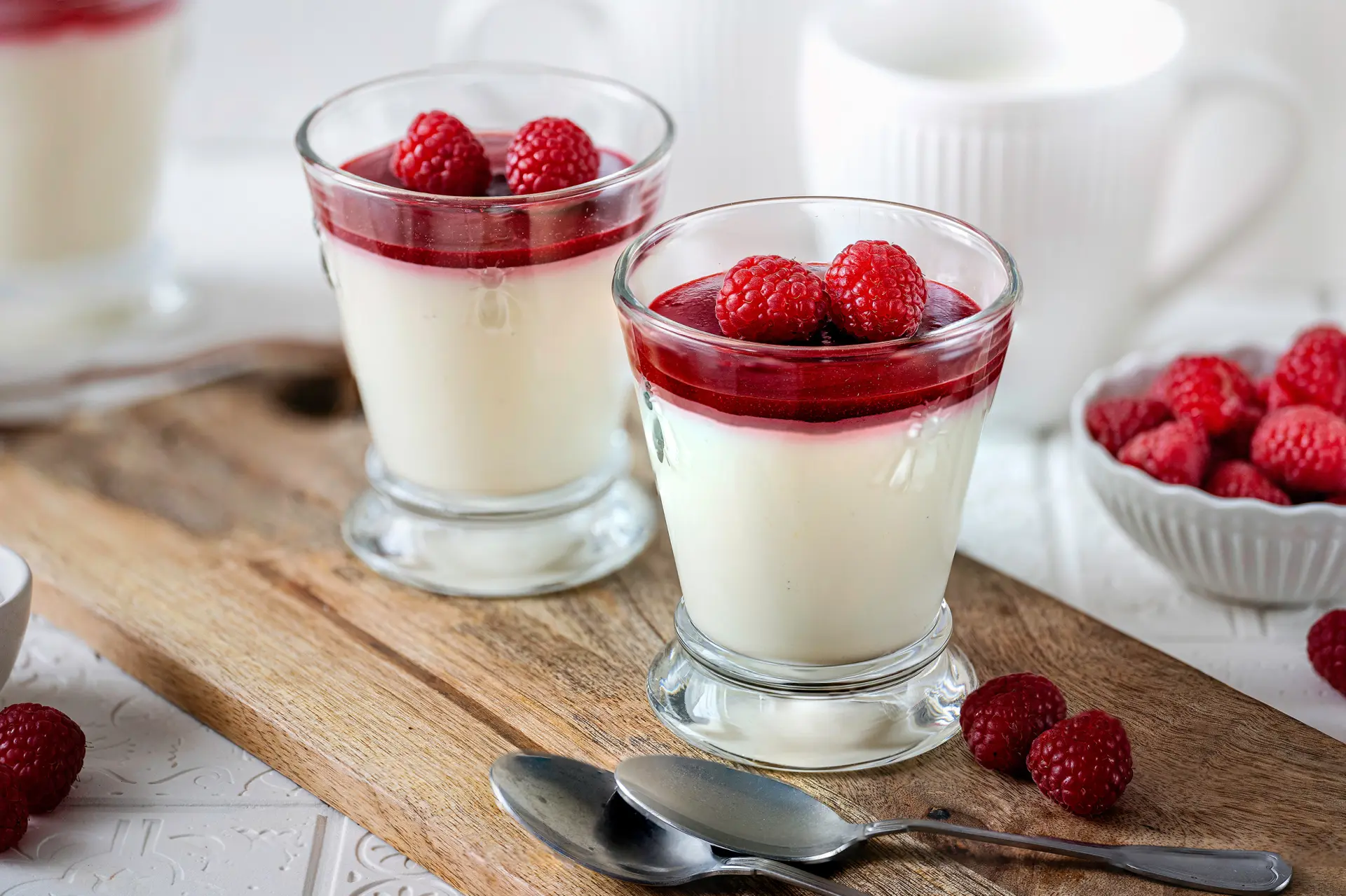 Bayerisch Creme mit Hagebutten Konfitüre-Himbeer-Spiegel Bayerische Creme im Glas mit roter Hagebuttensauce und frischen Himbeeren als Dessert.