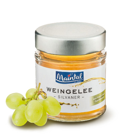 Weißwein-Gelee hergestellt aus fränkischem Silvaner Glas Weingelee Silvaner mit hellen Trauben neben dem Glas.