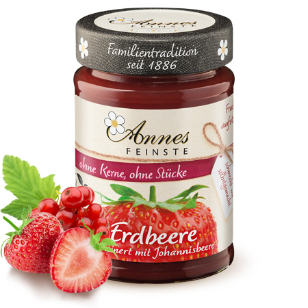 Annes Feinste Bio Erdbeere-rote Johannisbeere Fruchtaufstrich, fein passiert Glas Annes Feinste Bio Erdbeer-Johannisbeere Fruchtaufstrich. Daneben Früchte.