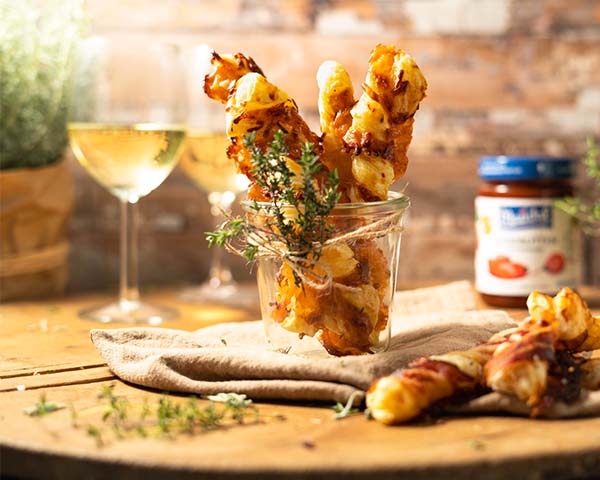 Blätterteigstangen mit Bacon und Käse Serviervorschlag Blätterteigstangen mit Bacon und Käse im Glas mit Weißwein und Hagebutten-Konfitüre.