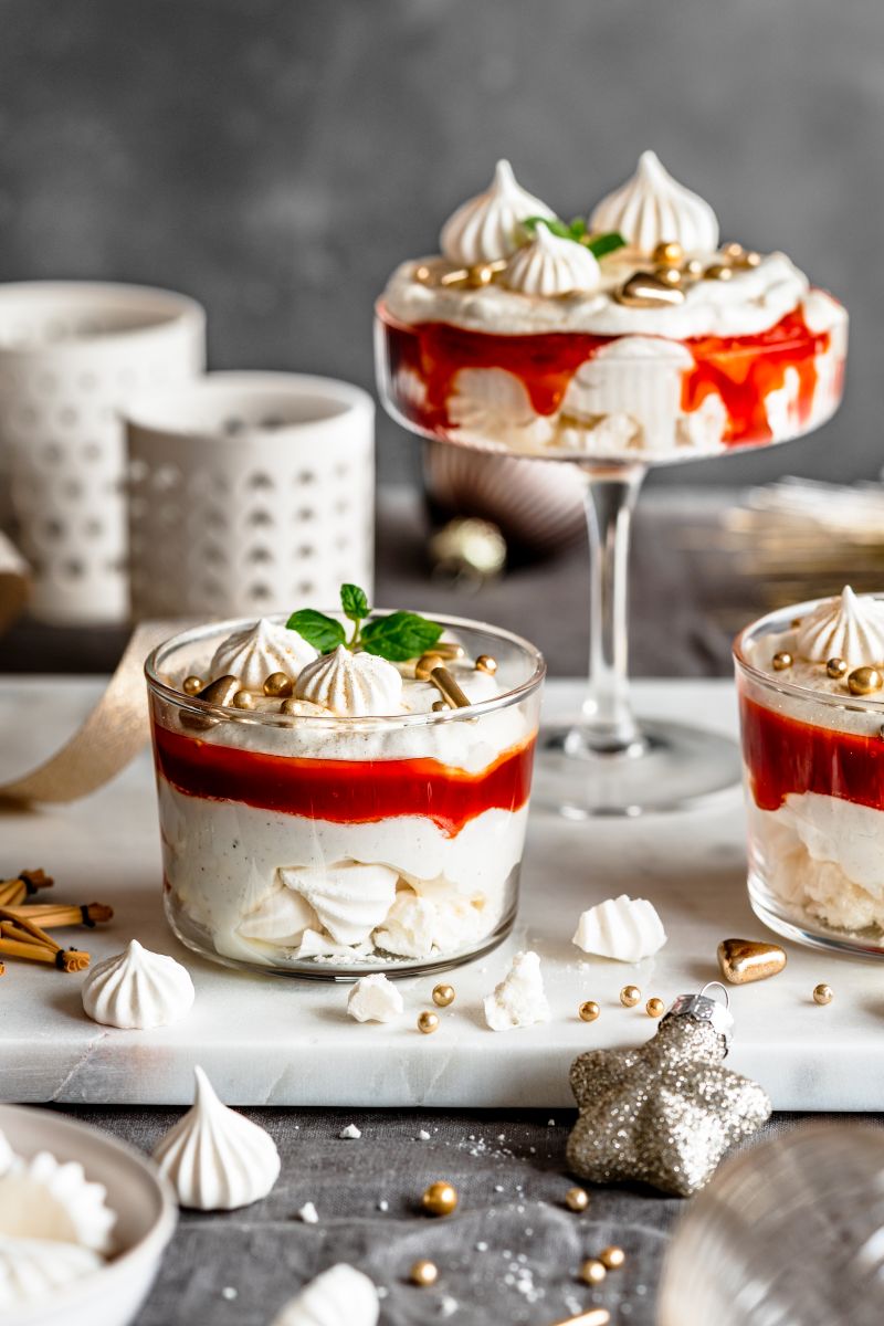Weihnachtliches Schichtdessert mit Hagebutten-Konfituere in unterschiedlichen Gläsern serviert.