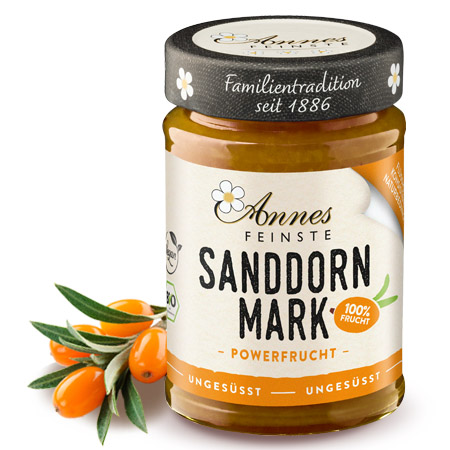 Annes Feinste Bio Sanddornmark Glas Annes Feinste Sanddornmark, daneben Sanddornbeeren.