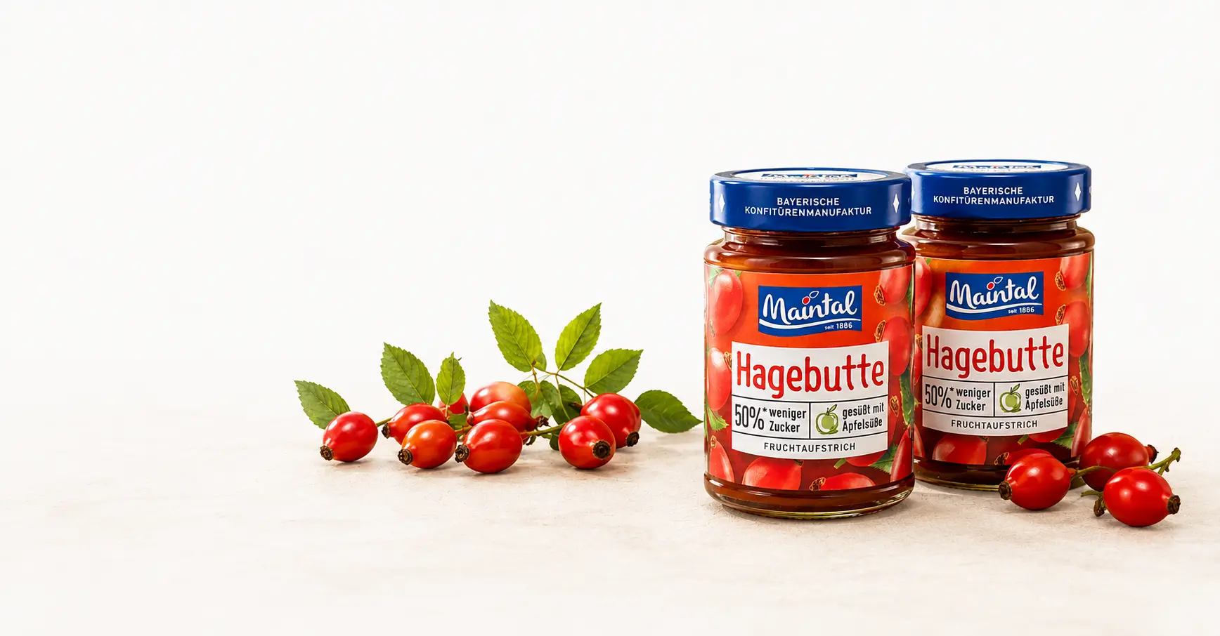 Zwei Maintal Hagebutten-Fruchtaufstriche mit 50 % weniger Zucker und frischen Hagebutten.