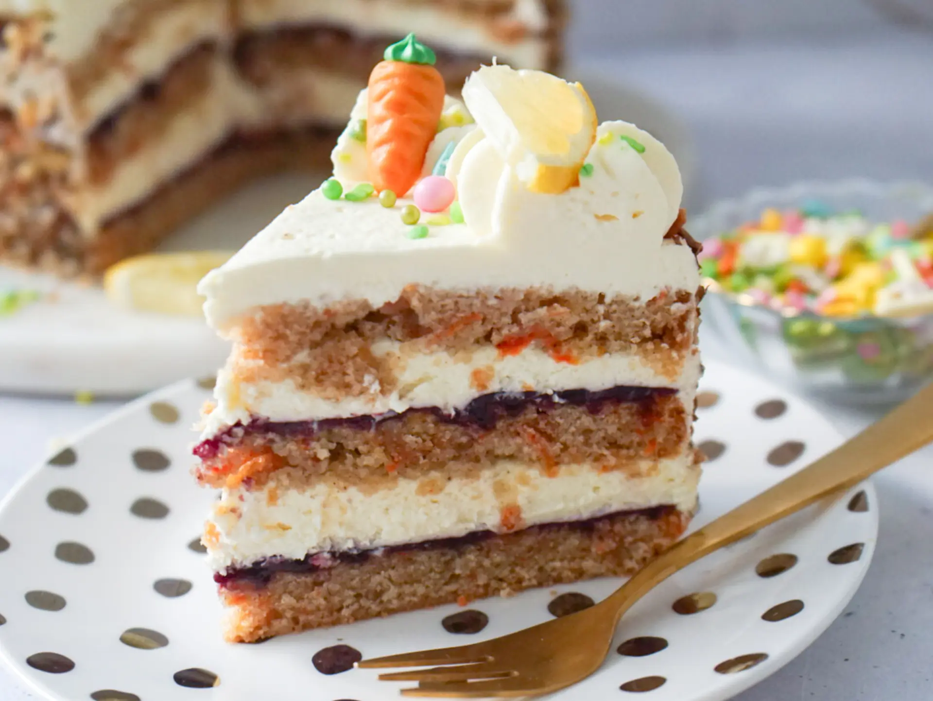 Rüblitorte mit Zitronencreme und Waldbeeren – Tortenstück Detailaufnahme eines Stücks Rüblitorte mit Zitronencreme und Waldbeeren Fruchtaufstrich, dekoriert mit Marzipan-Karotte.